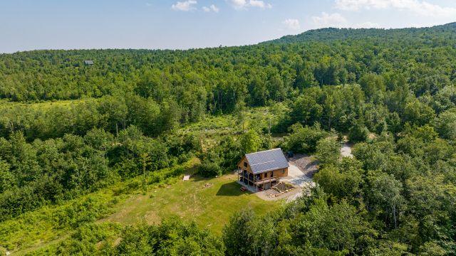 Aerial view of Runes Temple nestled in the Maine forest