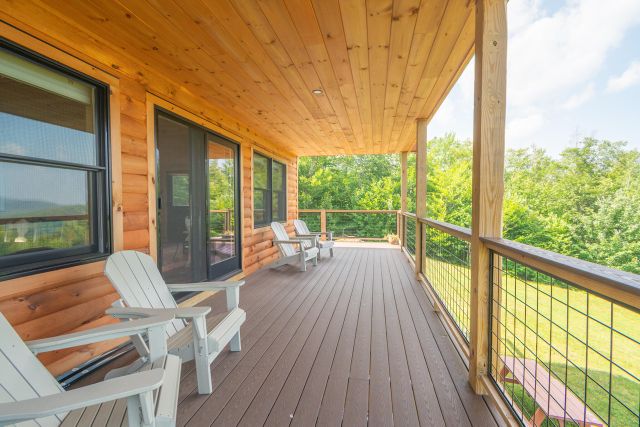 Wrap-around deck at Runes Temple with Adirondack chairs overlooking the forest
