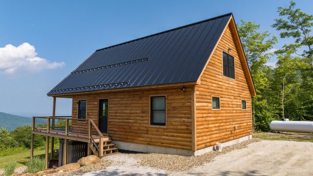 Close-up of Runes Temple cabin exterior with standing seam metal roof and blue sky